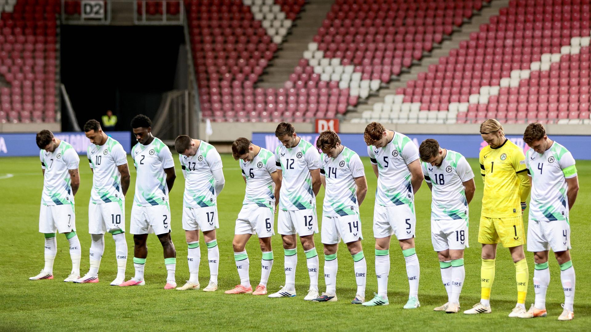 Die Startelf Irlands steht aufgerieht mit gesenkten Köpfen auf dem Rasen. Die Startelf Irlands steht aufgerieht mit gesenkten Köpfen auf dem Rasen.