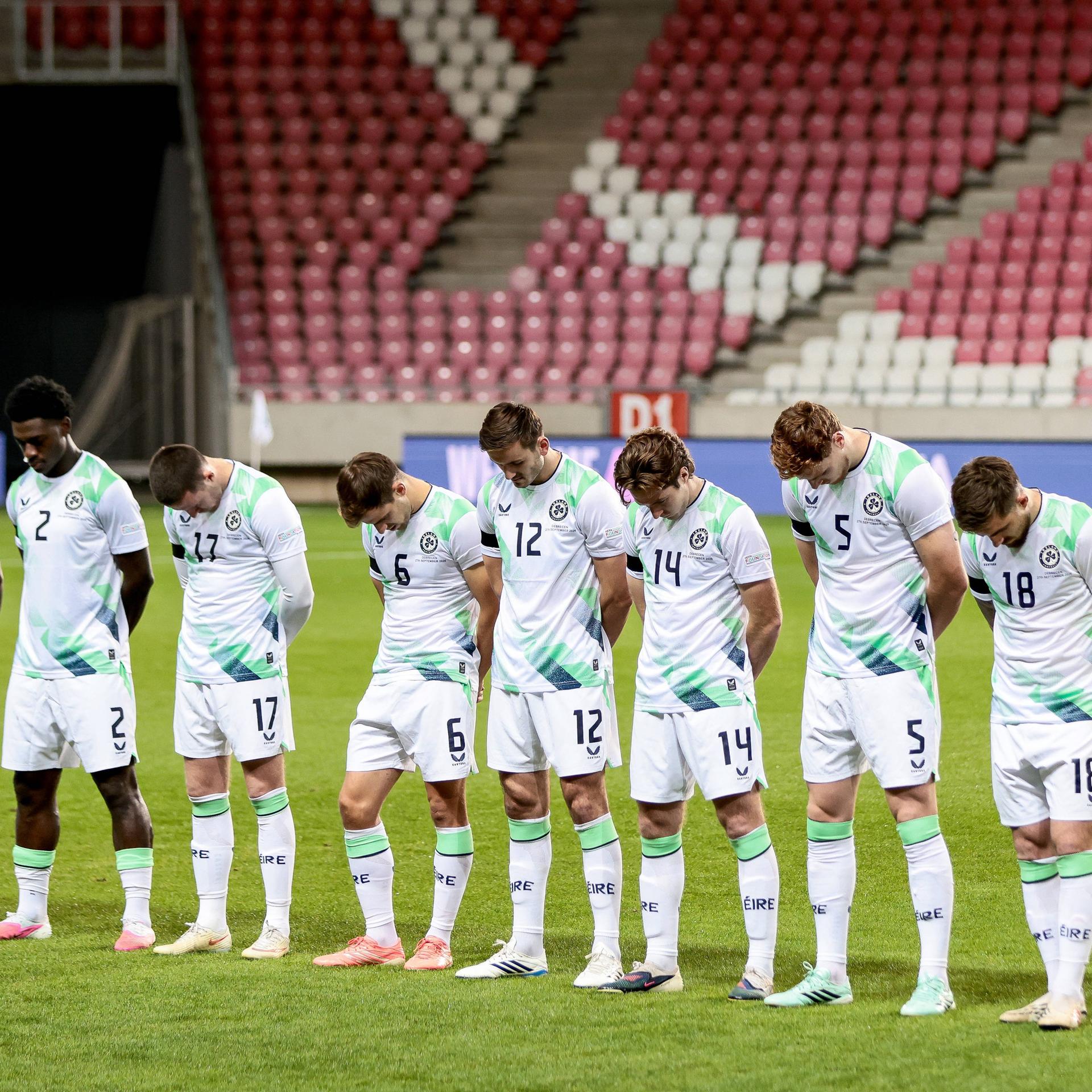 Die Startelf Irlands steht aufgerieht mit gesenkten Köpfen auf dem Rasen.