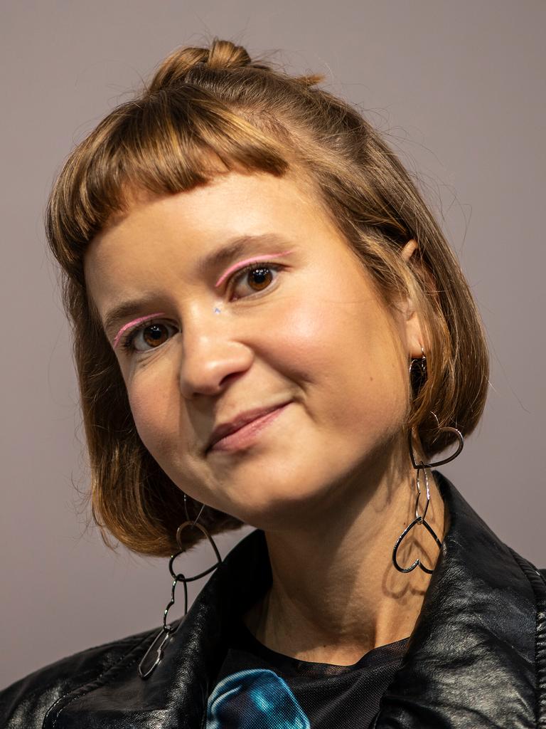 Caroline Wahl trägt eine schwarze Lederjacke, rosa Lidschatten und Ohrringe in Herzform. Sie schaut freundlich in die Kamera. Caroline Wahl trägt eine schwarze Lederjacke, rosa Lidschatten und Ohrringe in Herzform. Sie schaut freundlich in die Kamera.