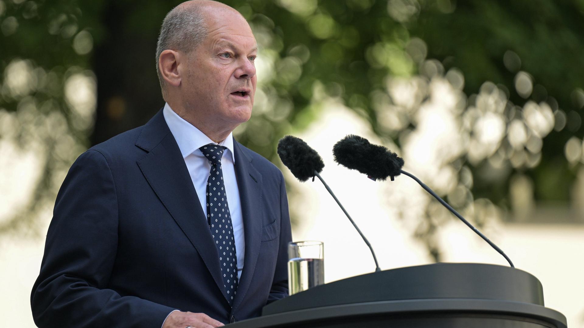 Olaf Scholz spricht an einem Rednerpult. Olaf Scholz spricht an einem Rednerpult.