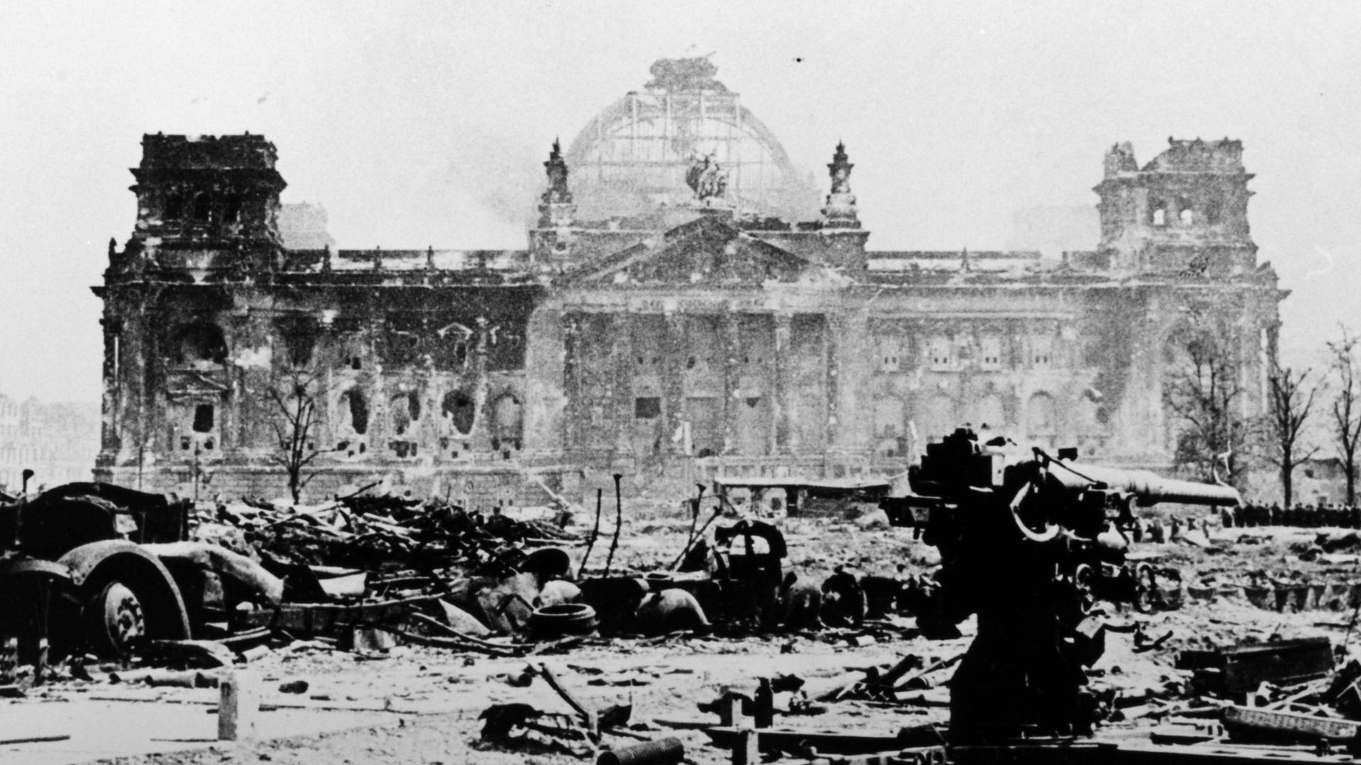 Ein verblichenes schwarz-weiß Foto des zerstörten Reichtagsgebäudes in Berlin im Mai 1945.