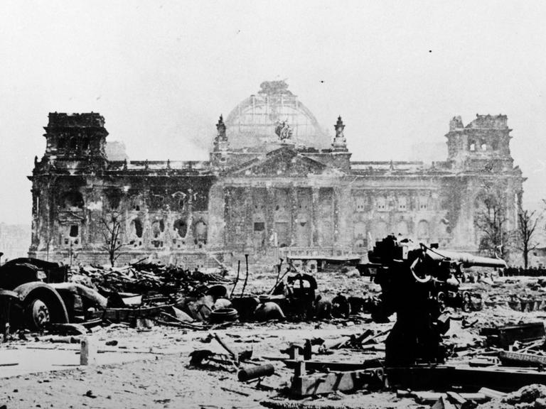 Ein verblichenes schwarz-weiß Foto des zerstörten Reichtagsgebäudes in Berlin im Mai 1945.