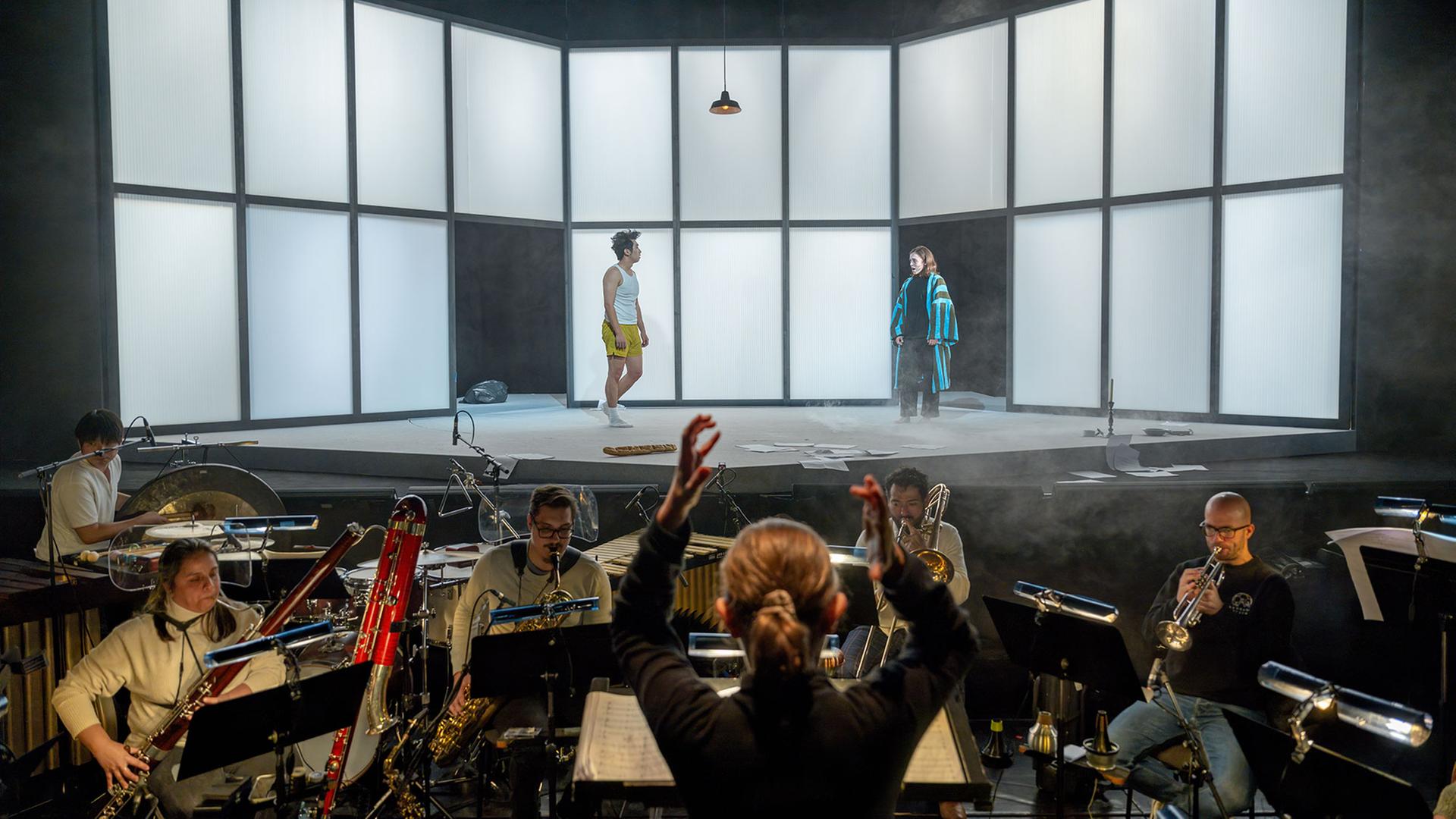 Ein Blick auf die Bühne mit zwei Darstellern und Musiker im Orchestergraben unter Leitung von Claire Levacher