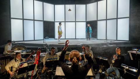 Ein Blick auf die Bühne mit zwei Darstellern und Musiker im Orchestergraben unter Leitung von Claire Levacher