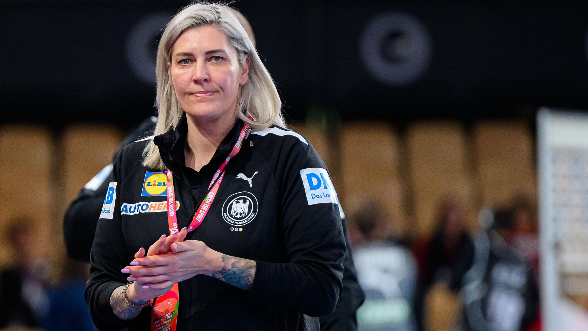 Die deutsche Handball-Teammanagerin Anja Althaus steht im schwarzen DHB-Outfit in der Halle.