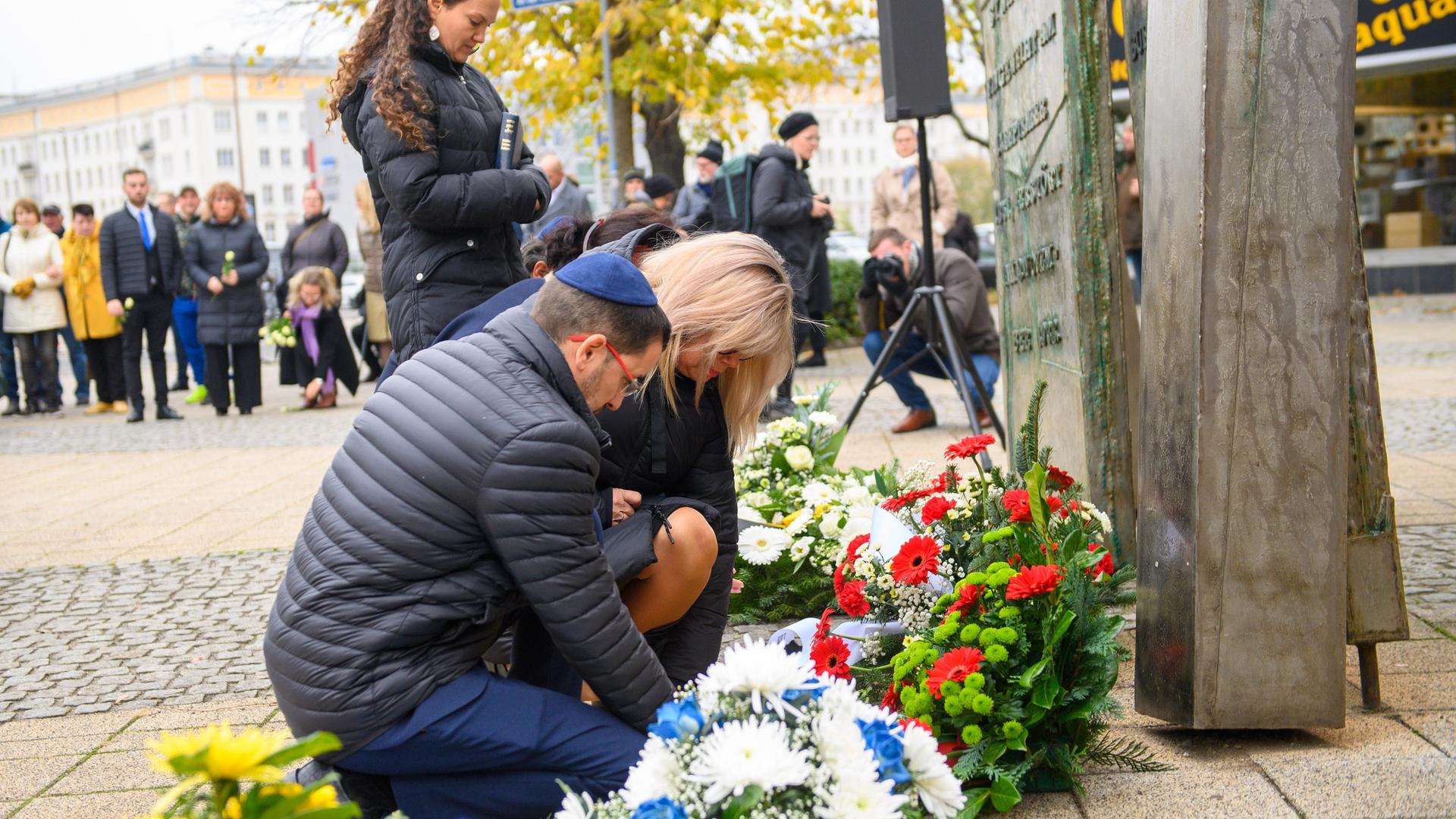 Magdeburg: Tziki Tzvi Avisar (l), Bürgermeister der Stadt Kiryat Motzkin in Israel und Simone Borris (r, Parteilos) Magdeburger Oberbürgermeisterin richten am Mahnmal für die zerstörte Synagoge die Bänder niedergelegter Kränze.