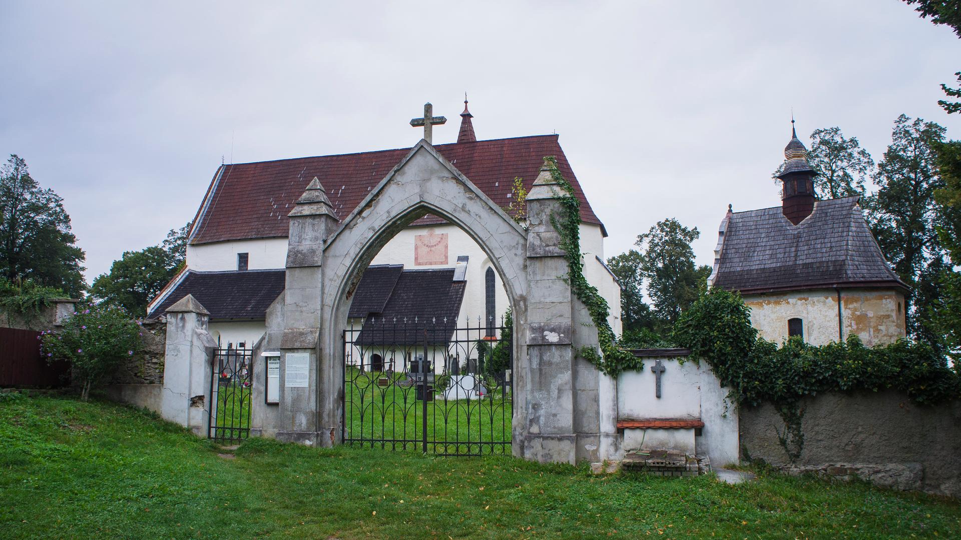 Blick auf das Eingangsportal zu den zwei Kirchen, die inmitten eines historisch geprägten Friedhofes liegen.