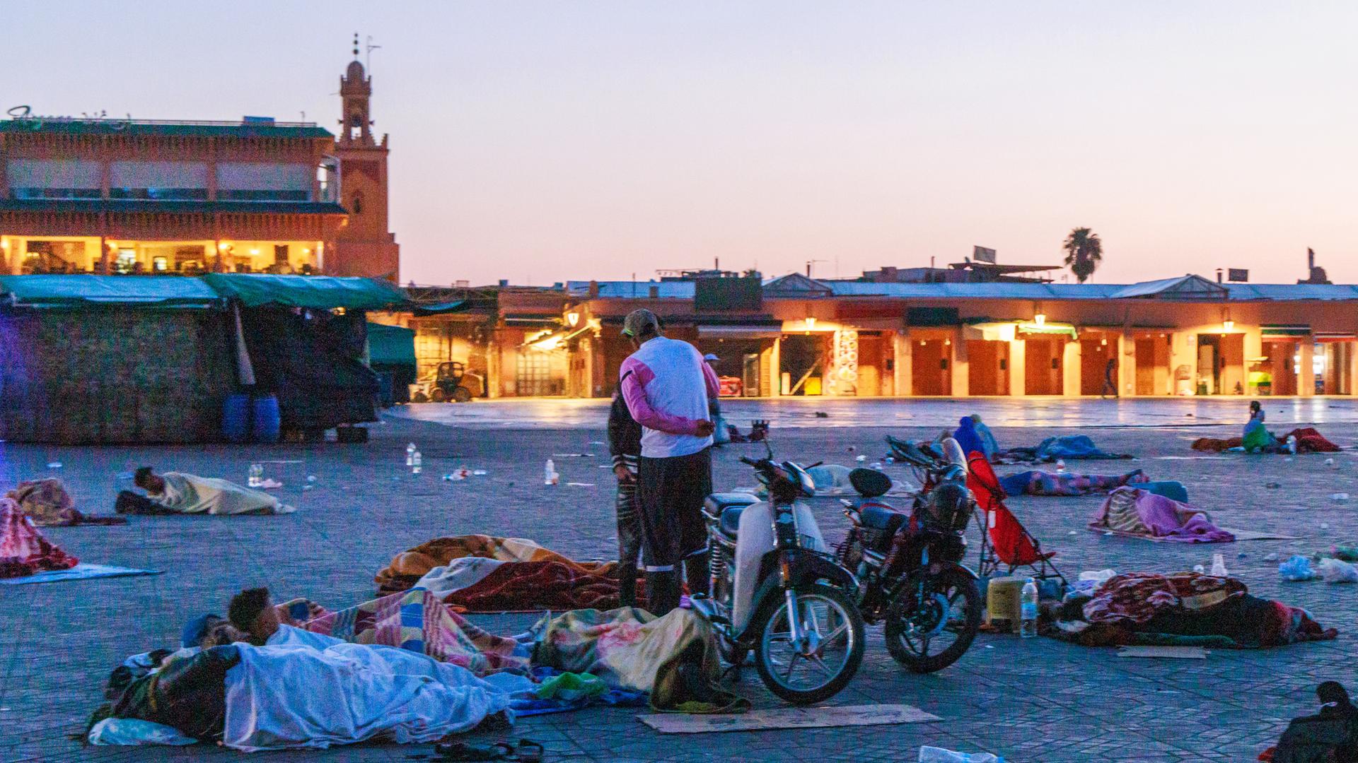 Menschen schlafen auf einem Platz in Marrakesch nach dem Erdbeben im Freien.