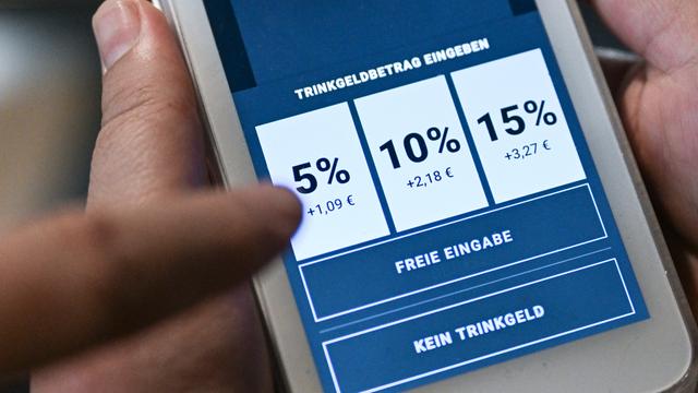 Auf einem Karten-Lesegerät werden deutlich Trinkgeld-Beträge angezeigt, die man bei der Zahlung antippen soll. Auch „Freie Eingabe“ und „Kein Trinkgeld“ sind möglich.