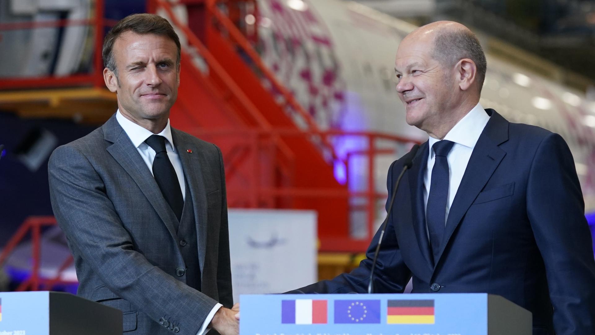Bundeskanzler Olaf Scholz (SPD) und Emmanuel Macron, Staatspräsident von Frankreich, reichen sich nach einem gemeinsamen Statement nach dem Besuch auf dem Airbus-Werksgelände in Hamburg-Finkenwerder die Hand. 