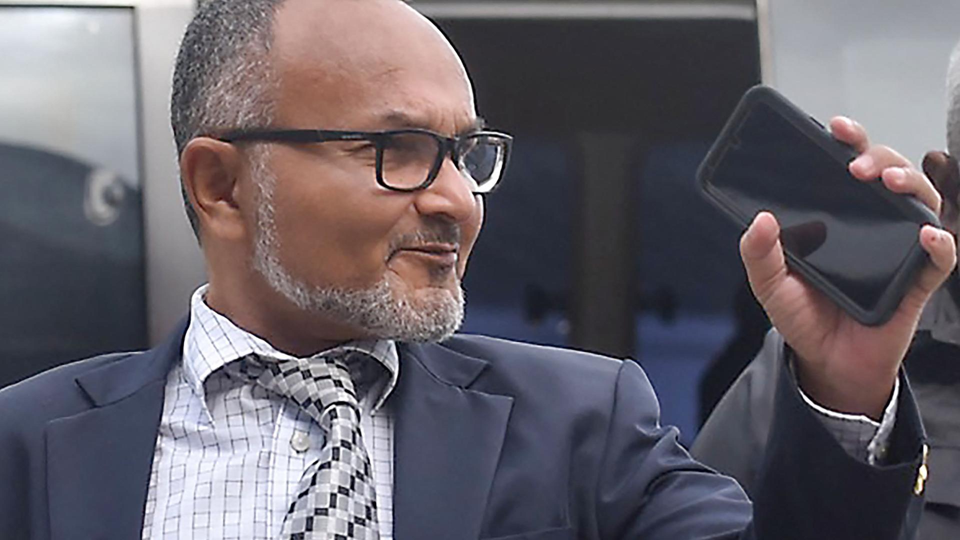 Matthew Wale, neue Regierungschef der Salomonen, guckt zur Seite und winkt mit einem Handy in der Hand. Matthew Wale, neue Regierungschef der Salomonen, guckt zur Seite und winkt mit einem Handy in der Hand.