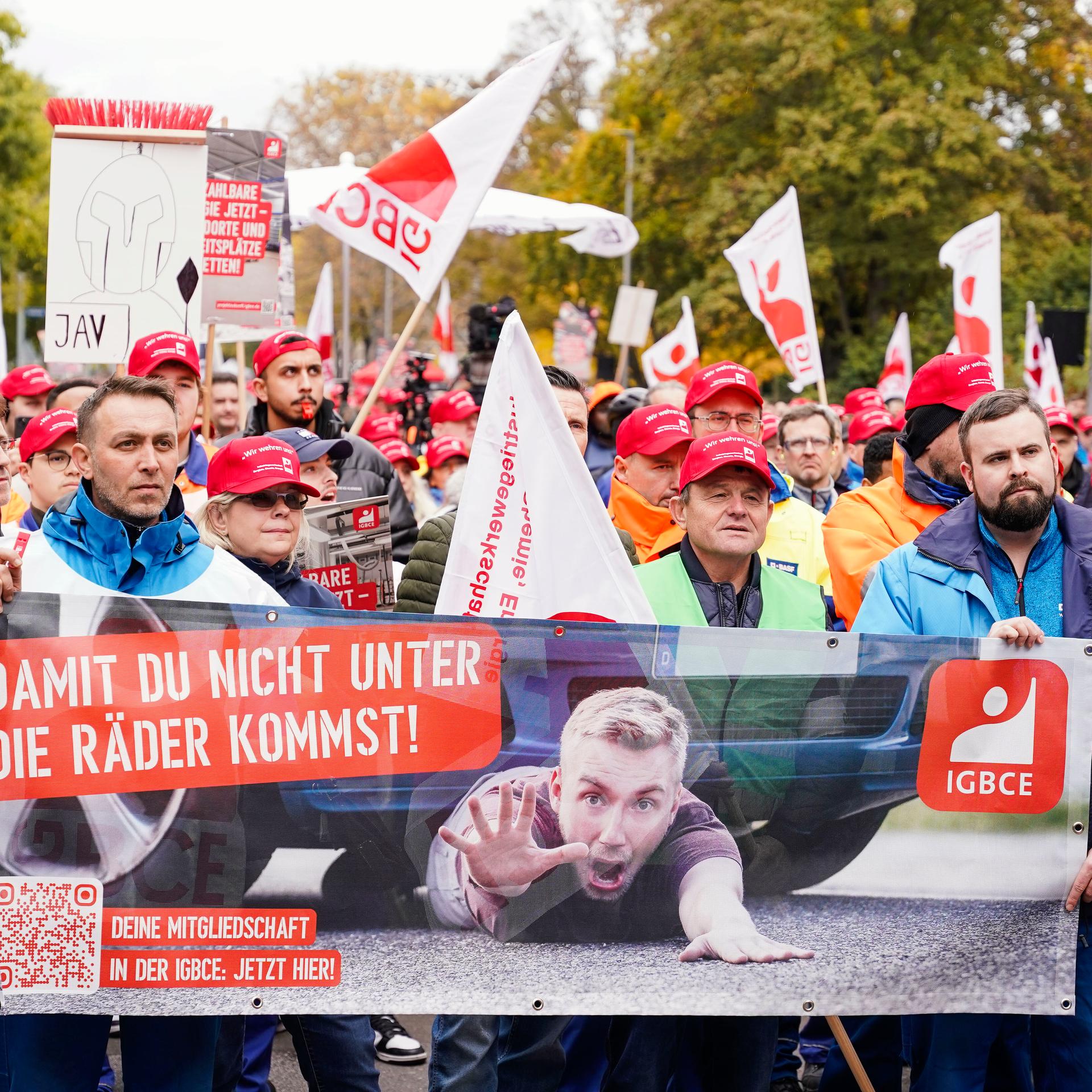 Teilnehmer halten bei einer Kundgebung ein Transparent mit der Aufschrift „Damit du nicht unter die Räder kommst!“ in den Händen. Die Gewerkschaft IG BCE und Beschäftigte der Chemieindustrie fordern einen bis 2030 befristeten Preisdeckel für Strom.