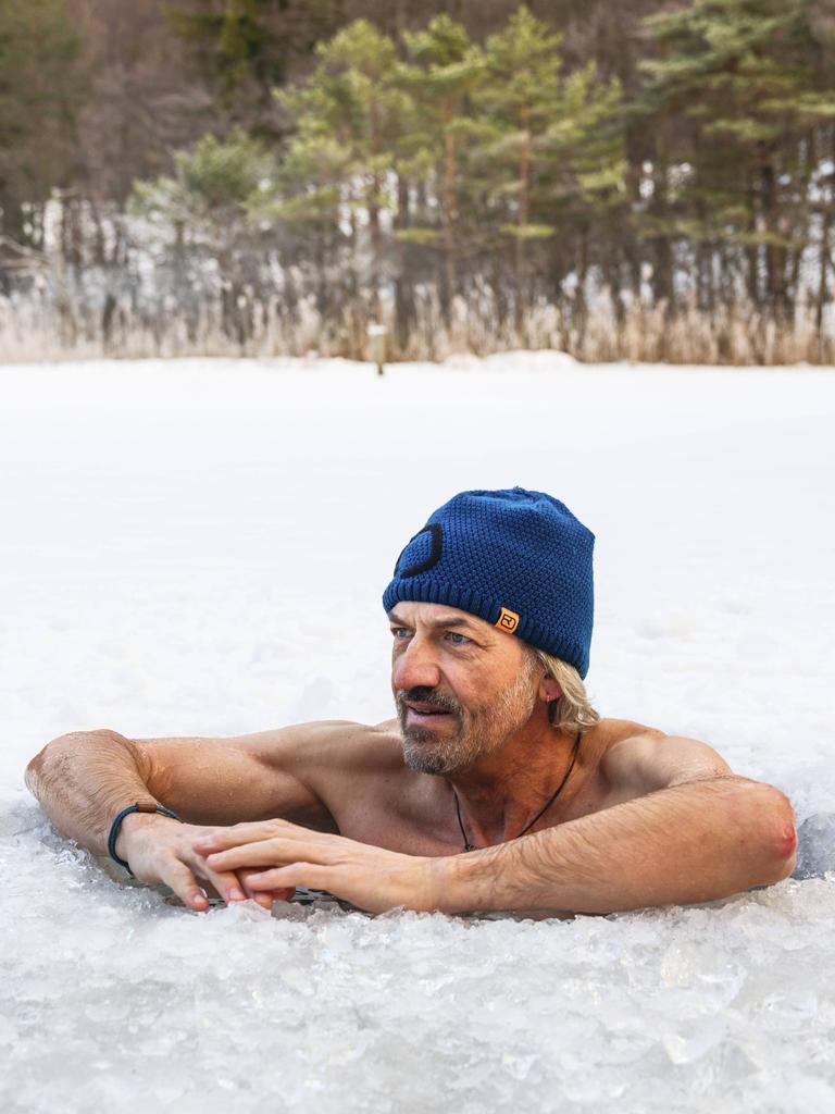 Ein Mann mit Mütze legt beim Eisbaden im Thumsee bei Bad Reichenhall in Bayern seine Arme auf die Eisoberfläche. Ein Mann mit Mütze legt beim Eisbaden im Thumsee bei Bad Reichenhall in Bayern seine Arme auf die Eisoberfläche.