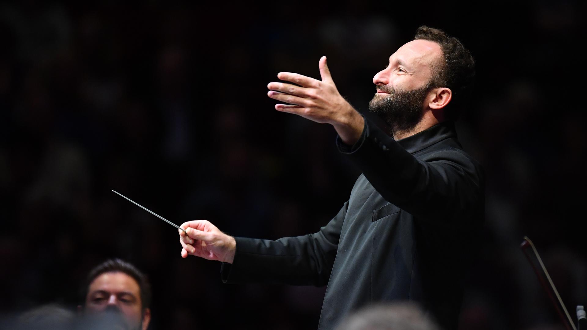 Kirill Petrenko dirigiert mit ausladender Geste.