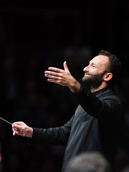 Kirill Petrenko dirigiert mit ausladender Geste.