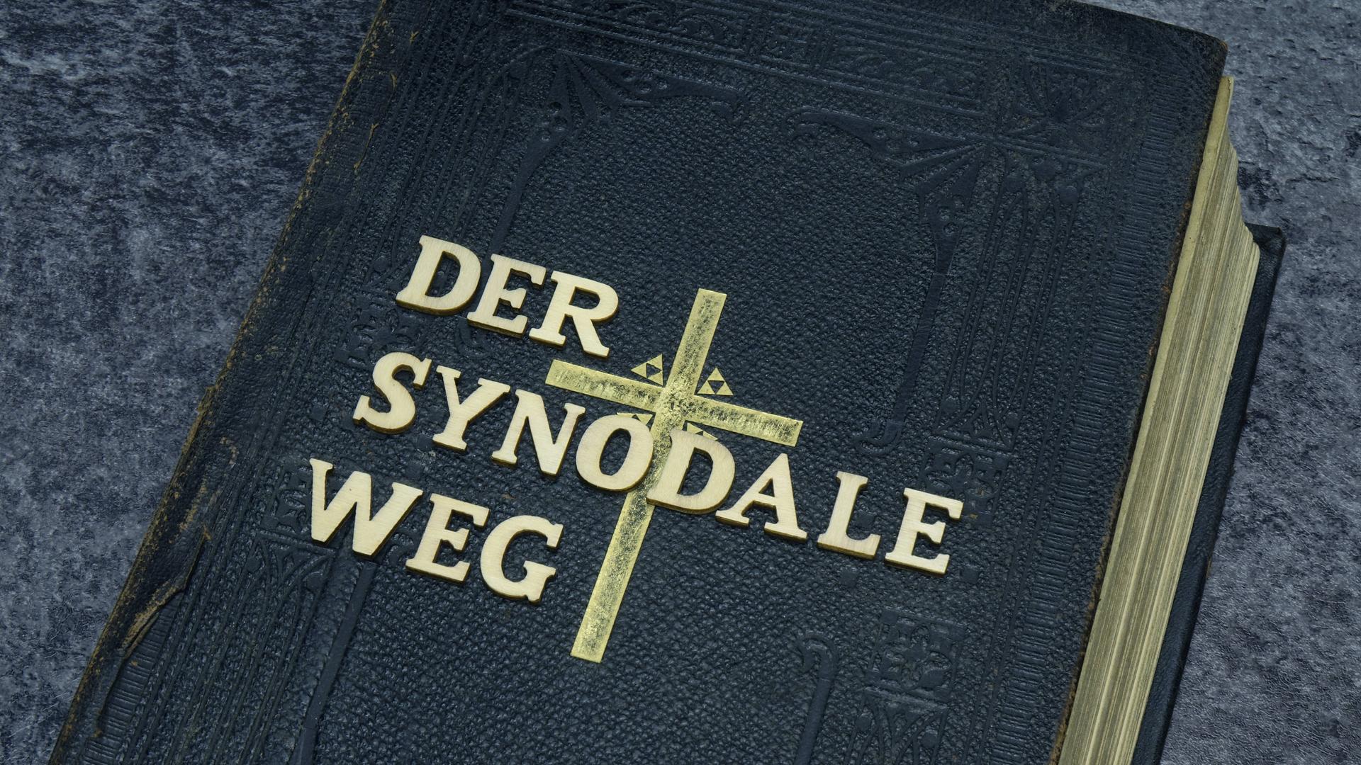 Auf einer Bibel liegt der Schriftzug Der Synodale Weg.
