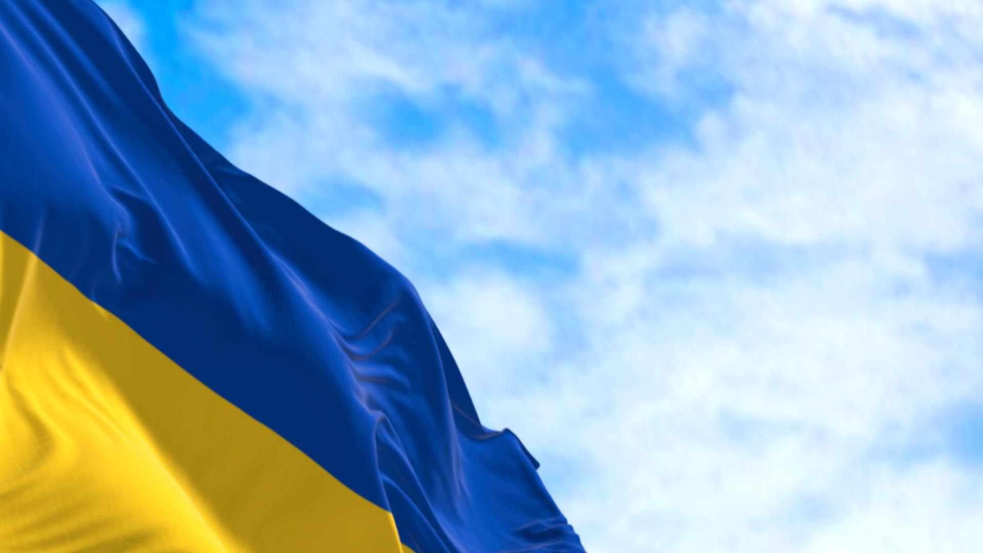 Die ukrainische Flagge weht unter blauem Himmel.