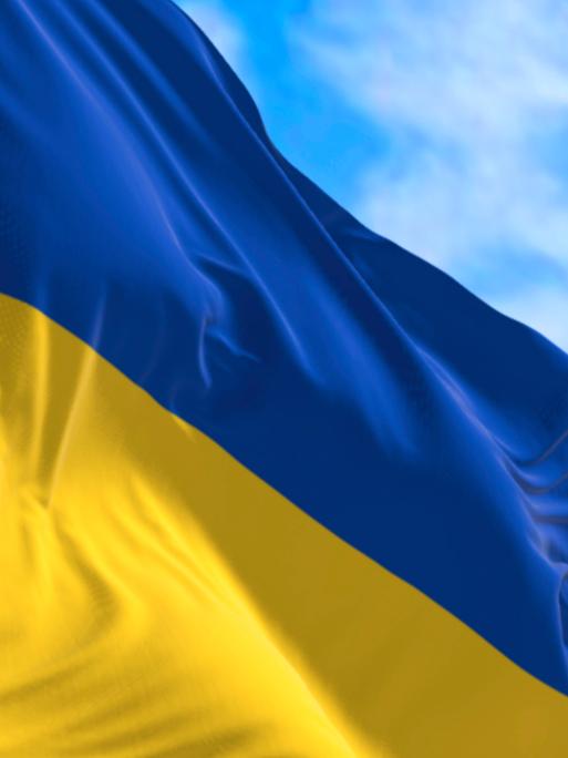 Die ukrainische Flagge weht unter blauem Himmel.