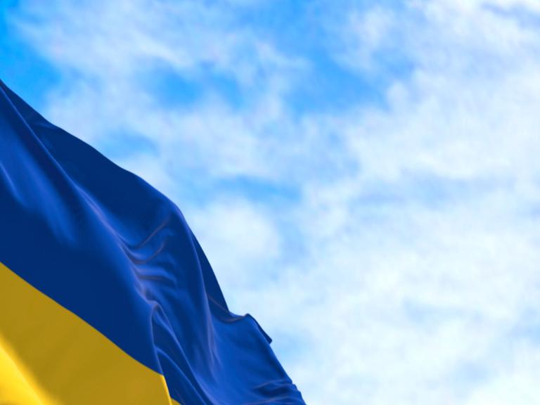 Die ukrainische Flagge weht unter blauem Himmel.