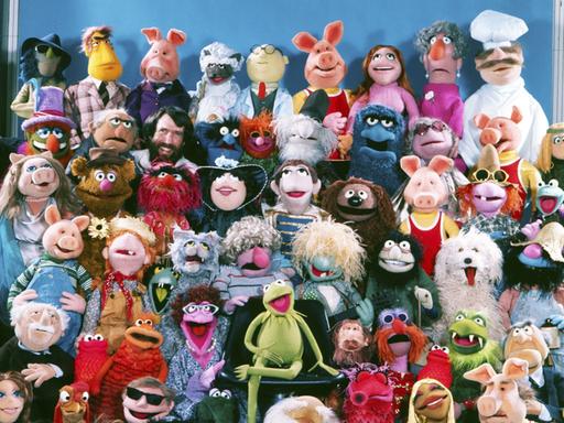 Puppengruppenbild der Muppet-Show mit (neben vielen anderen) Miss Piggy, Kermit, dem schwedischen Koch, Fozzybär und natürlich dem Muppets-Erfinder Jim Henson