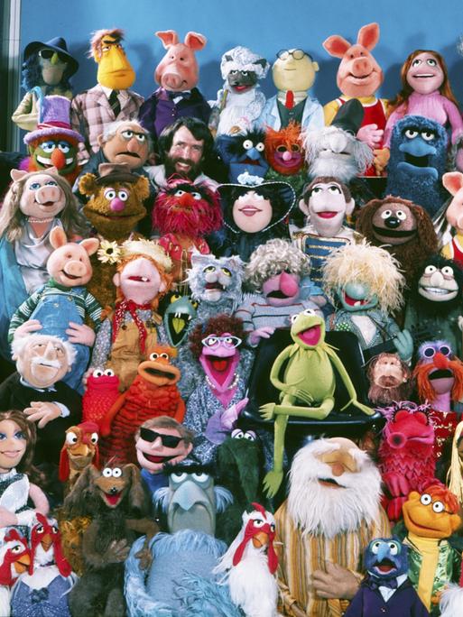 Puppengruppenbild der Muppet-Show mit (neben vielen anderen) Miss Piggy, Kermit, dem schwedischen Koch, Fozzybär und natürlich dem Muppets-Erfinder Jim Henson