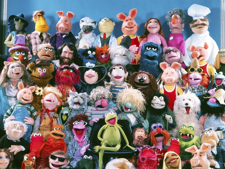 Puppengruppenbild der Muppet-Show mit (neben vielen anderen) Miss Piggy, Kermit, dem schwedischen Koch, Fozzybär und natürlich dem Muppets-Erfinder Jim Henson