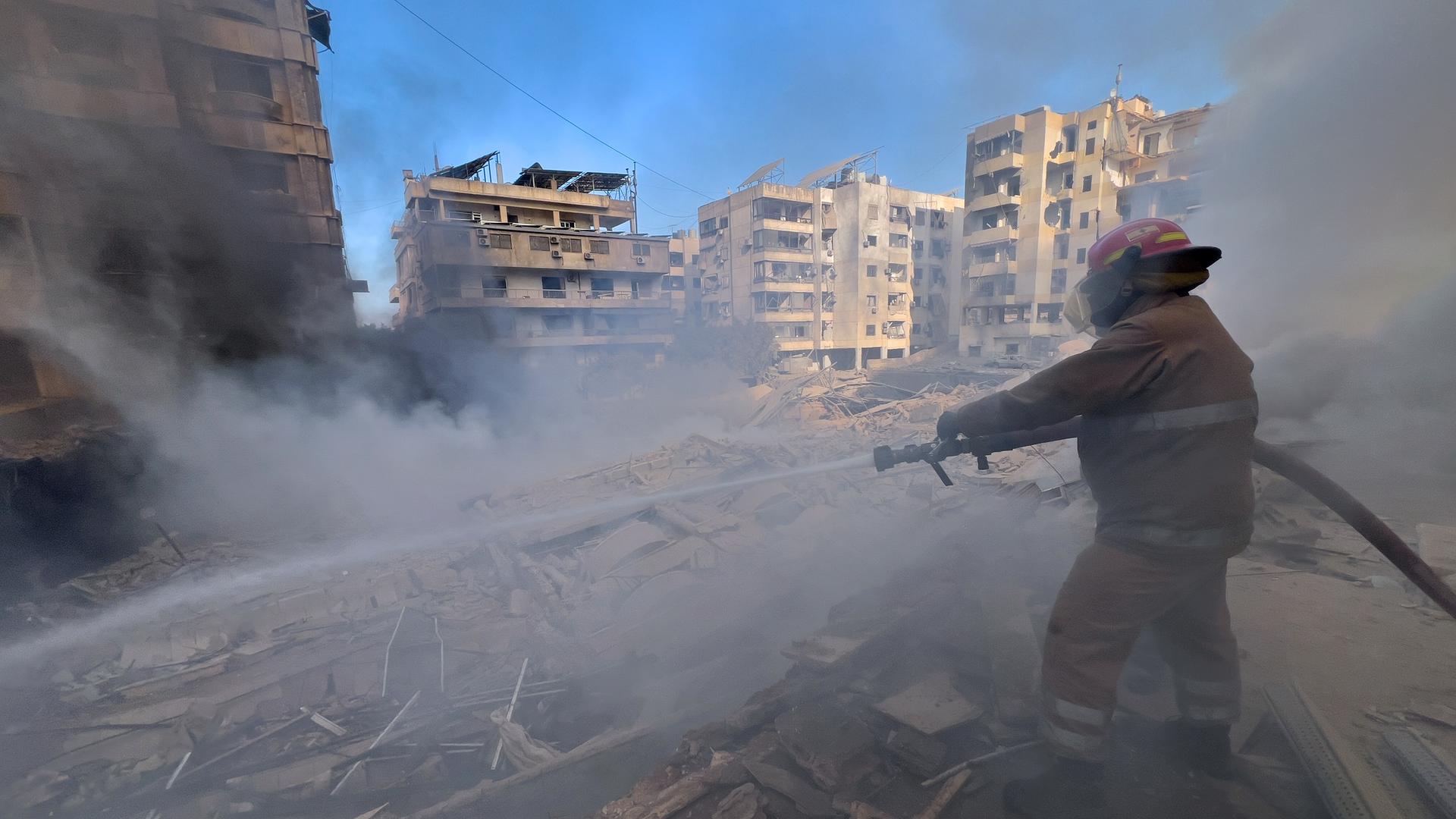 Ein Feuerwehrmann löscht in Dahiyeh, einem südlichen Vorort von Beirut im Libanon, einen Brand in einem Gebäude, das von einem israelischen Luftangriff getroffen wurde. Ein Feuerwehrmann löscht in Dahiyeh, einem südlichen Vorort von Beirut im Libanon, einen Brand in einem Gebäude, das von einem israelischen Luftangriff getroffen wurde.