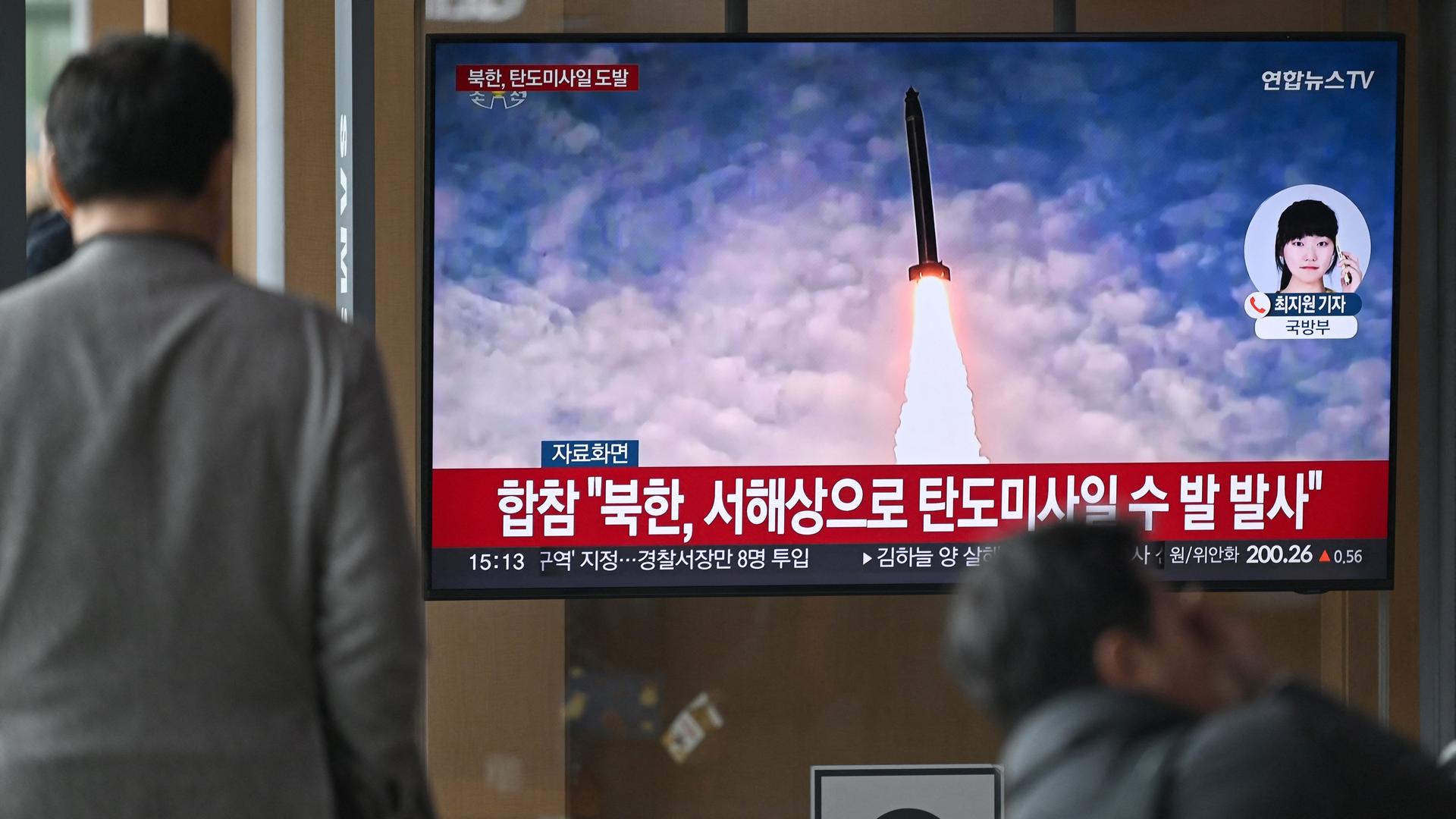 People watch a television screen showing a news broadcast with file footage of a North Korean missile test, at a train station in Seoul on March 10, 2025. North Korea fired "multiple unidentified ballistic missiles", South Korea's military said.