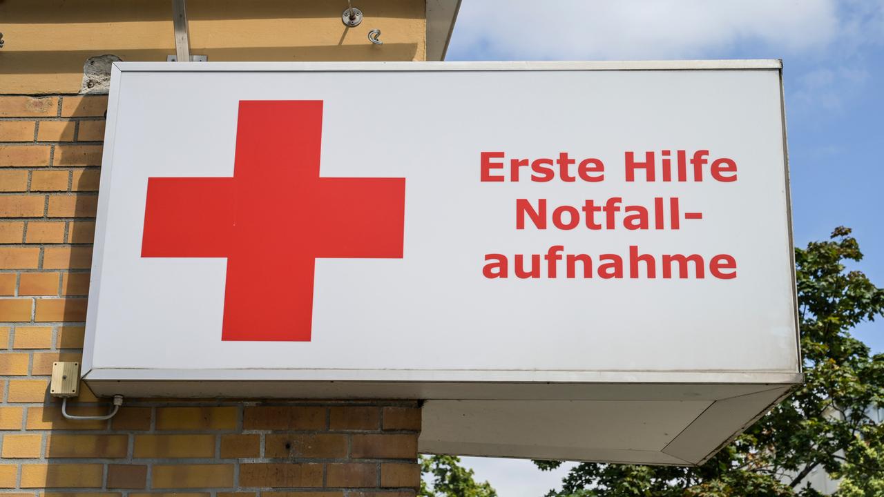 Auf einem Schild sind neben einem roten Kreuz die Worte "Erste Hilfe, Notaufnahme" zu lesen.