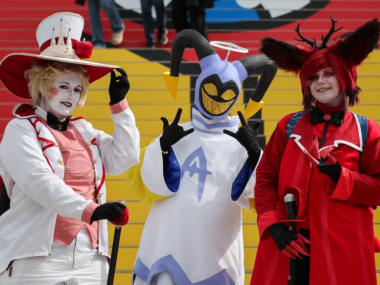 Drei Cosplayer stehen in ihren Kostümen auf der Leipziger Buchmesse 2024.