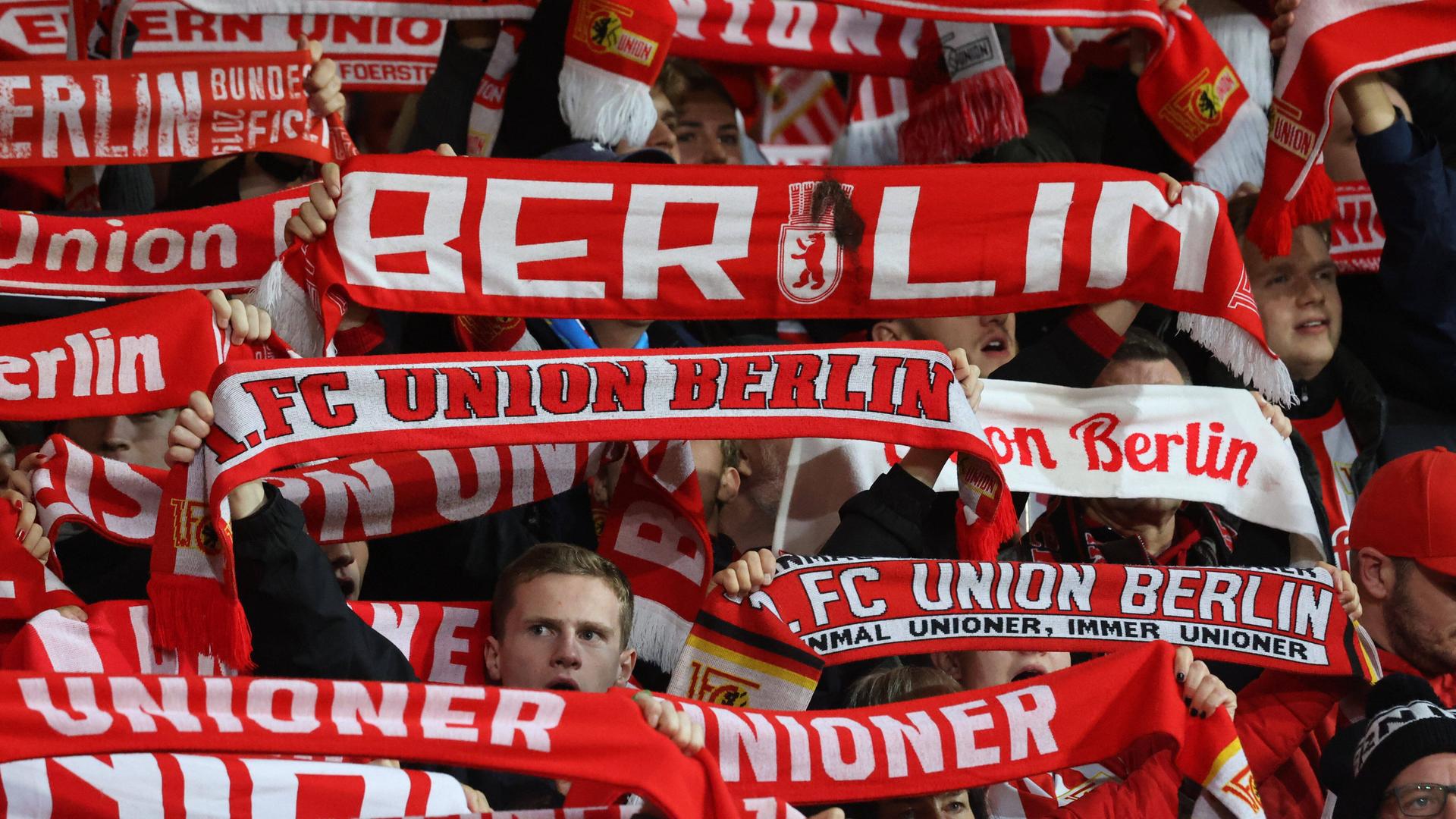 Fans von Union Berlin mit Fanschals im Stadion.