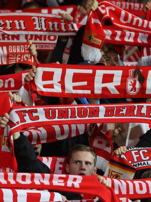 Fans von Union Berlin mit Fanschals im Stadion.