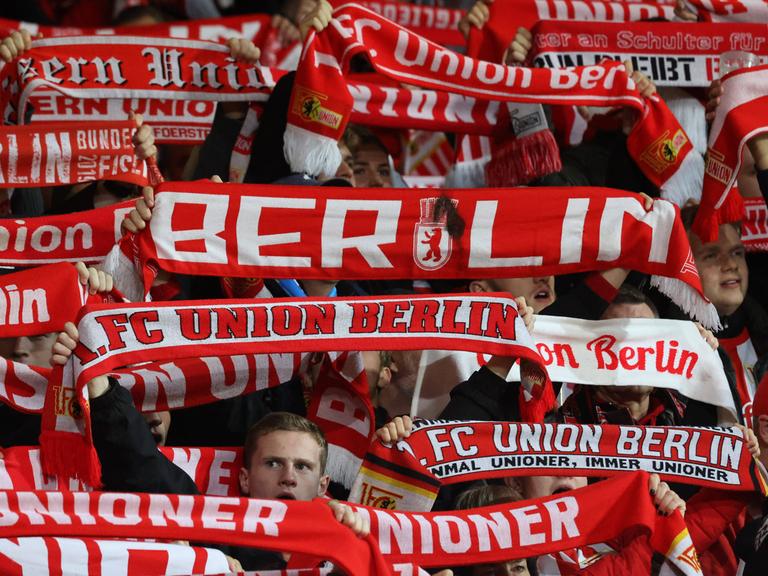 Fans von Union Berlin mit Fanschals im Stadion.