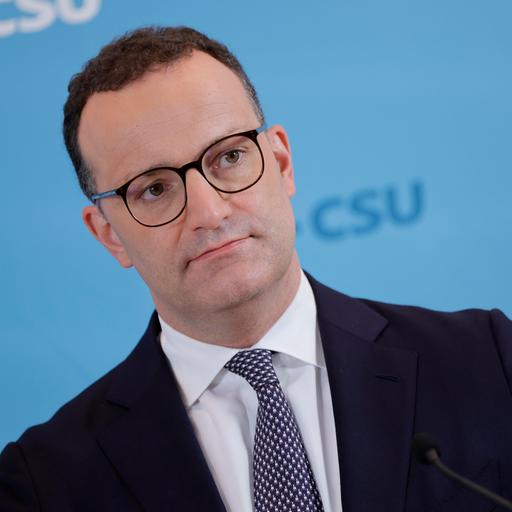 Jens Spahn von den Schultern an aufwärts. Er trägt dunkles Sakko, weißes Hemd und eine Krawatte.