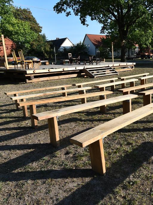 Theaterbühne und Bänke sind am 22.09.2016 in Garlitz (Brandenburg) aufgebaut. Holzbänke stehen vor einer Bühne auf einer Wiese.