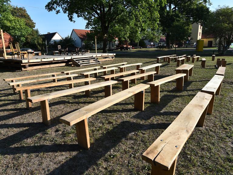 Theaterbühne und Bänke sind am 22.09.2016 in Garlitz (Brandenburg) aufgebaut. Holzbänke stehen vor einer Bühne auf einer Wiese.