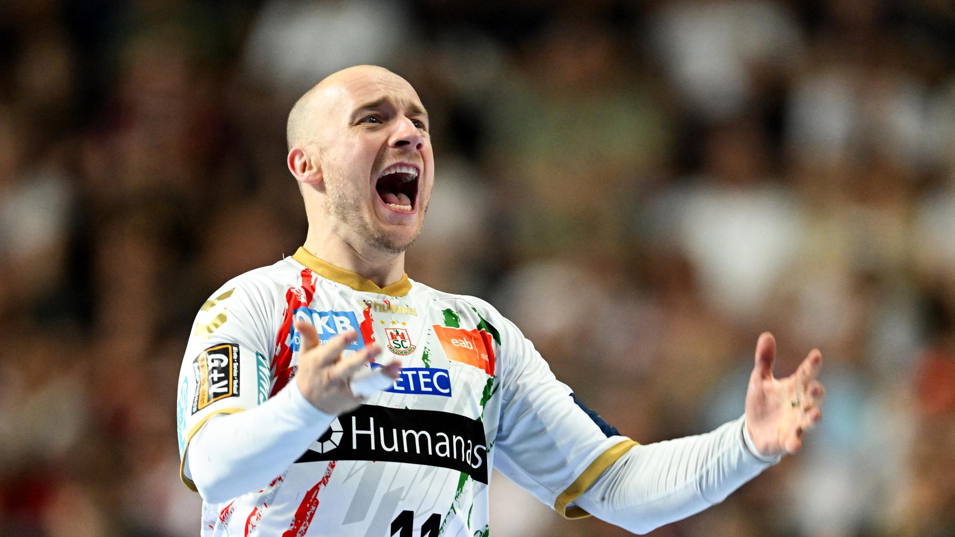 Der Spieler im weißen Trikot schreit seine Freude heraus. Der Spieler im weißen Trikot schreit seine Freude heraus.