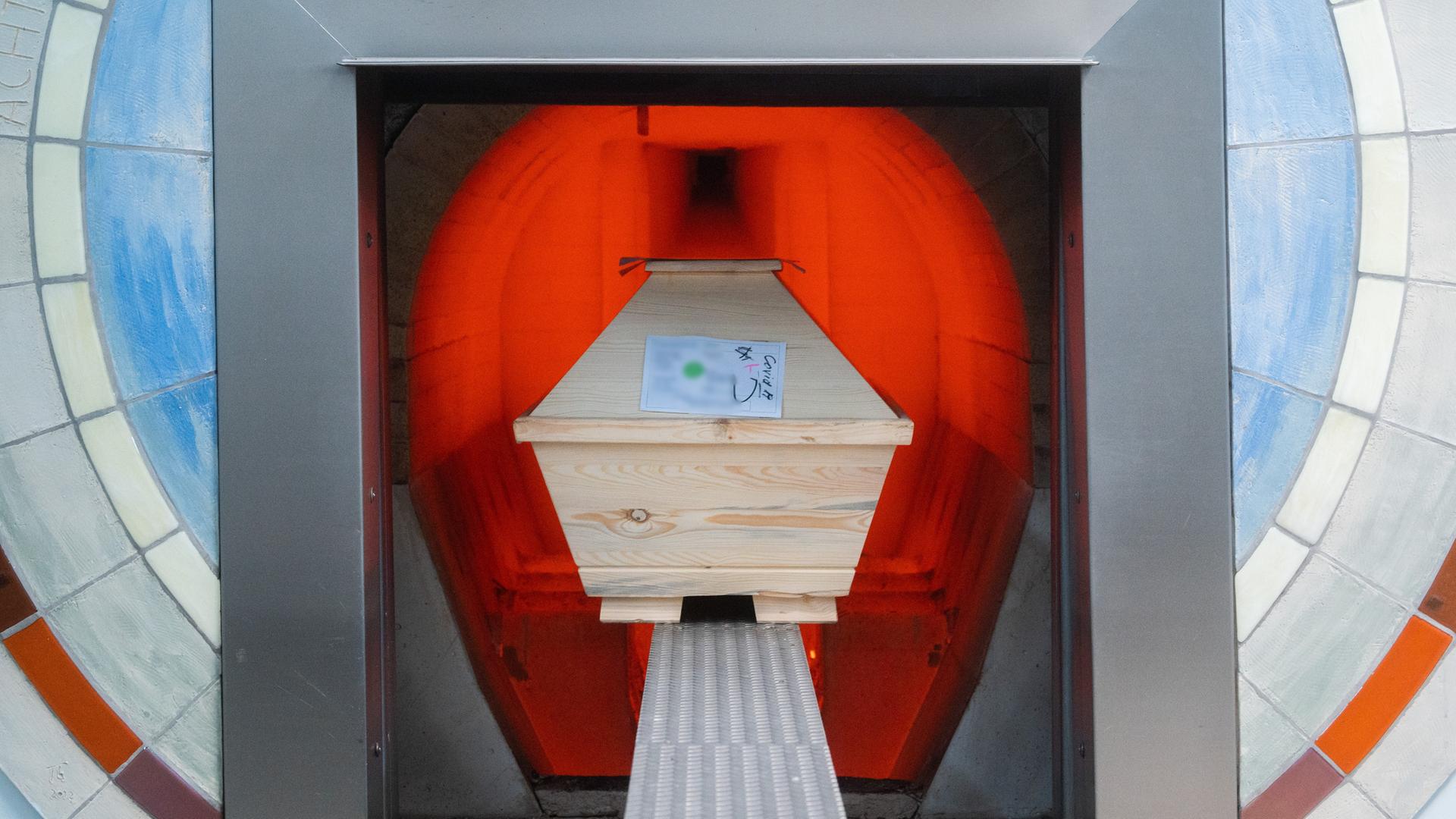 Ein Verstorbener in einem Sarg mit Aufschrift "Covid-19" wird im Krematorium "Die Feuerbestattungen Hildesheim" in einem Ofen eingeäschert. Ãber 5200 Menschen in Niedersachsen sind seit Beginn der Pandemie im Zusammenhang mit Corona gestorben - aber ihre Zahl steigt langsamer.
