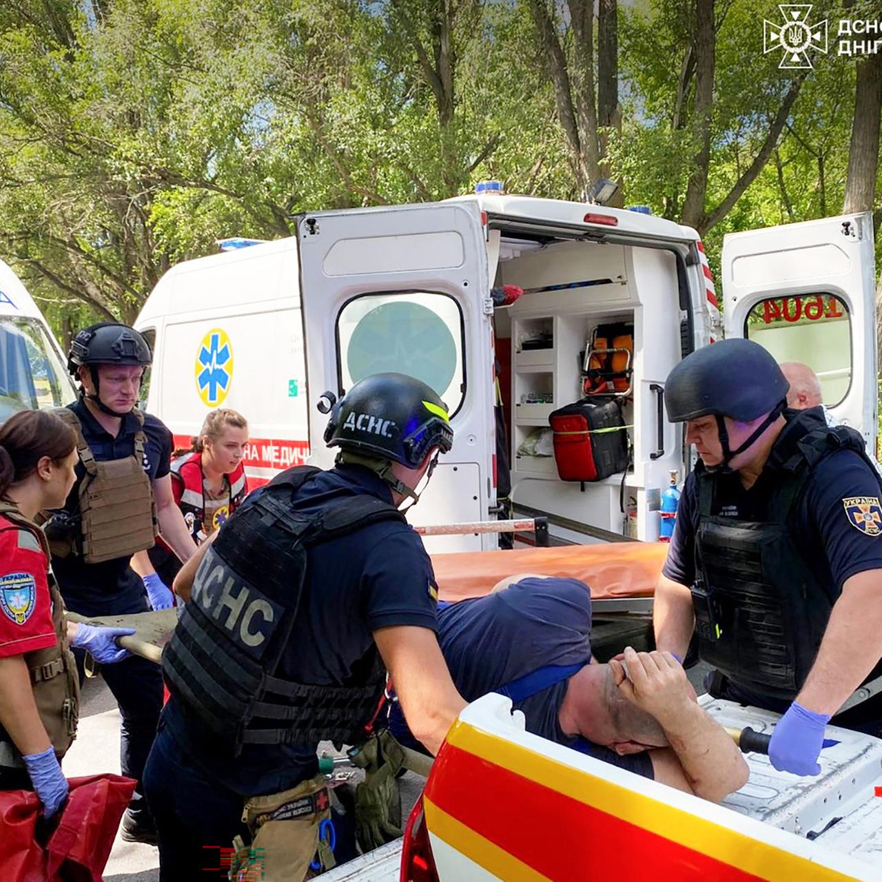 Ein verletzter Mann wird von Sanitätern in einen Krankenwagen getragen.