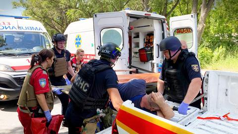 Ein verletzter Mann wird von Sanitätern in einen Krankenwagen getragen.