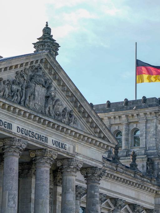 Reichstag in Berlin - Deutscher Bundestag mit Deutschlandflagge.