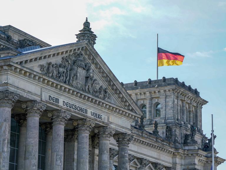 Reichstag in Berlin - Deutscher Bundestag mit Deutschlandflagge.