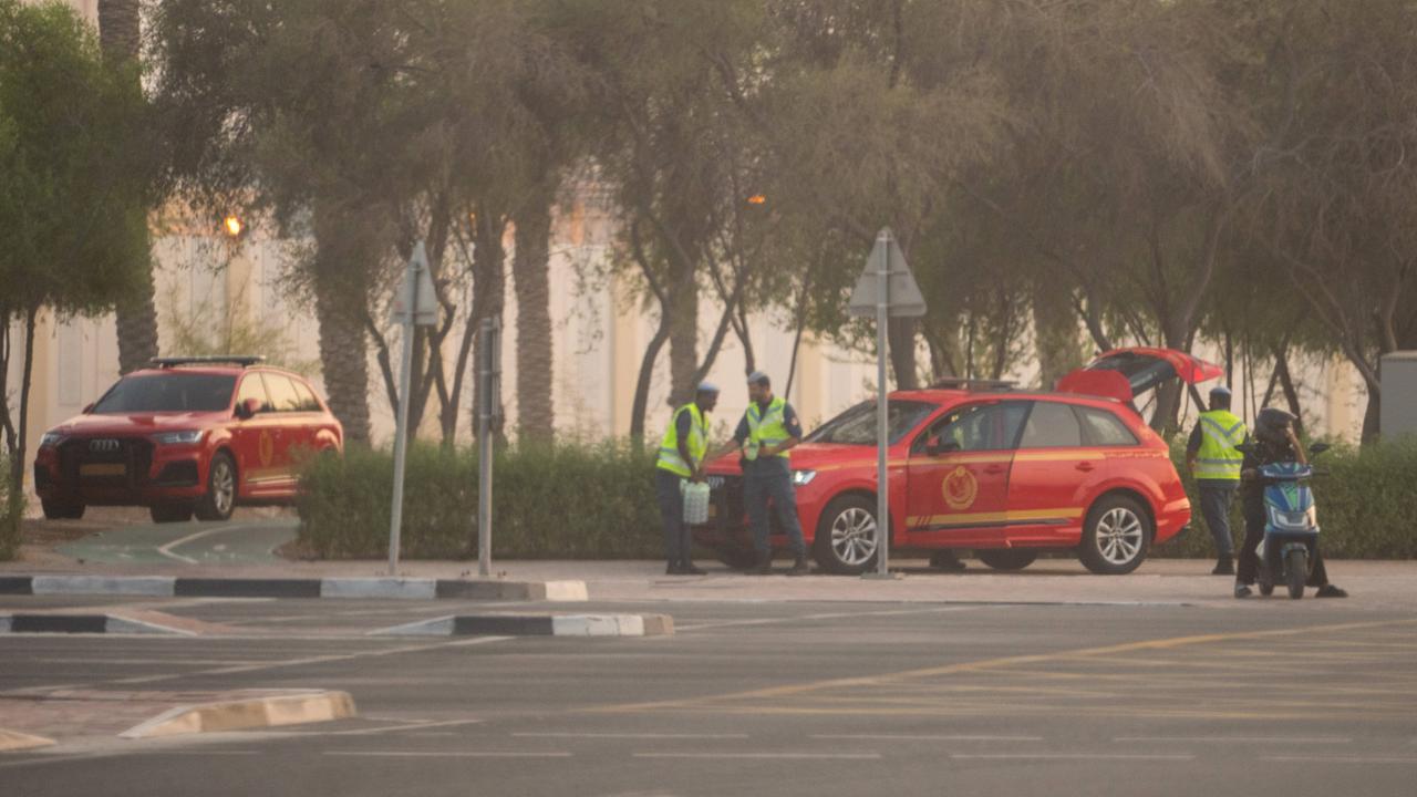 Sicherheitspersonal mit zwei roten Autos stehen in der Nähe des Anschlags in Doha.