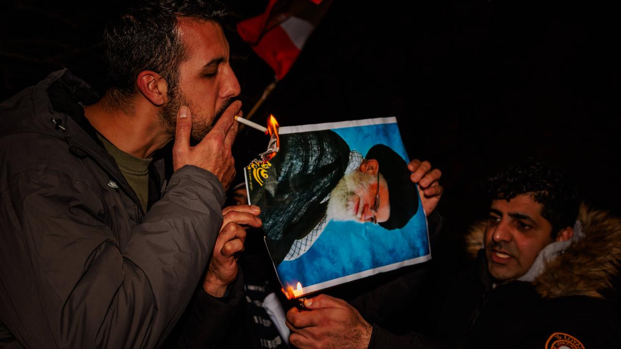 Bei Protesten in London, Großbritannien, zündet ein Mann mit einer Zigarette ein Bildnis des iranischen Revolutionsführers an (12. Januar 2026)
