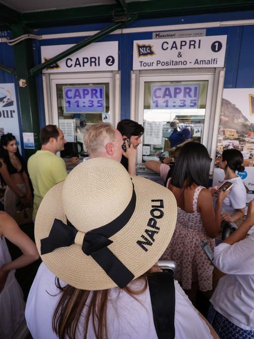 Das Foto zeigt Touristen in Neapel, die auf die Überfahrt nach Capri warten.