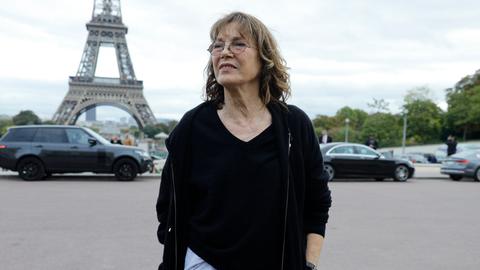 Jane Birkin steht im Oktober 2017 vor dem Eiffelturm. Sie trägt eine braune Kordhose und einen schwarzen Pulli im Oversized-Look.