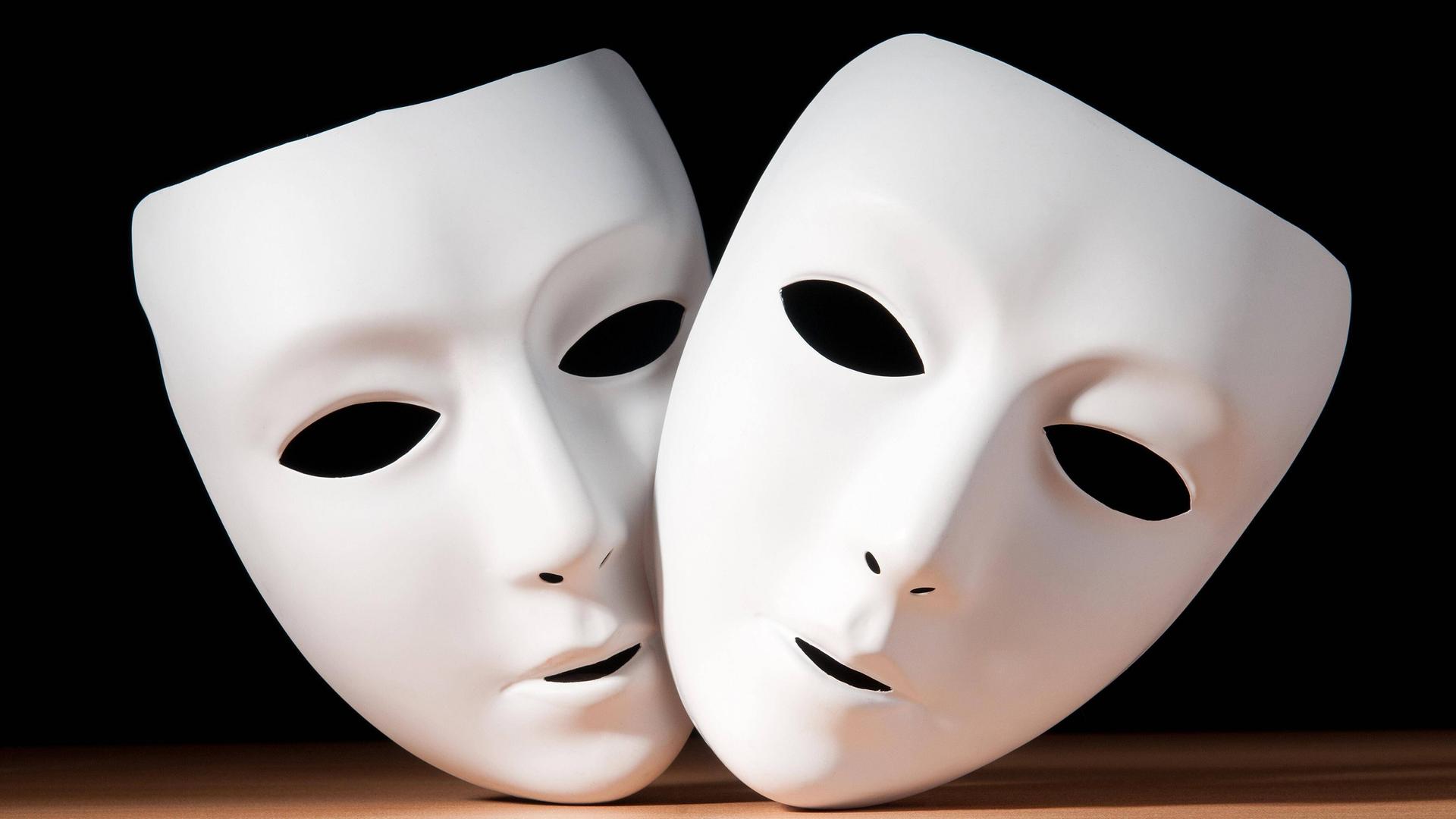 Zwei weiße Gesichtsmasken vor schwarzem Hintergrund