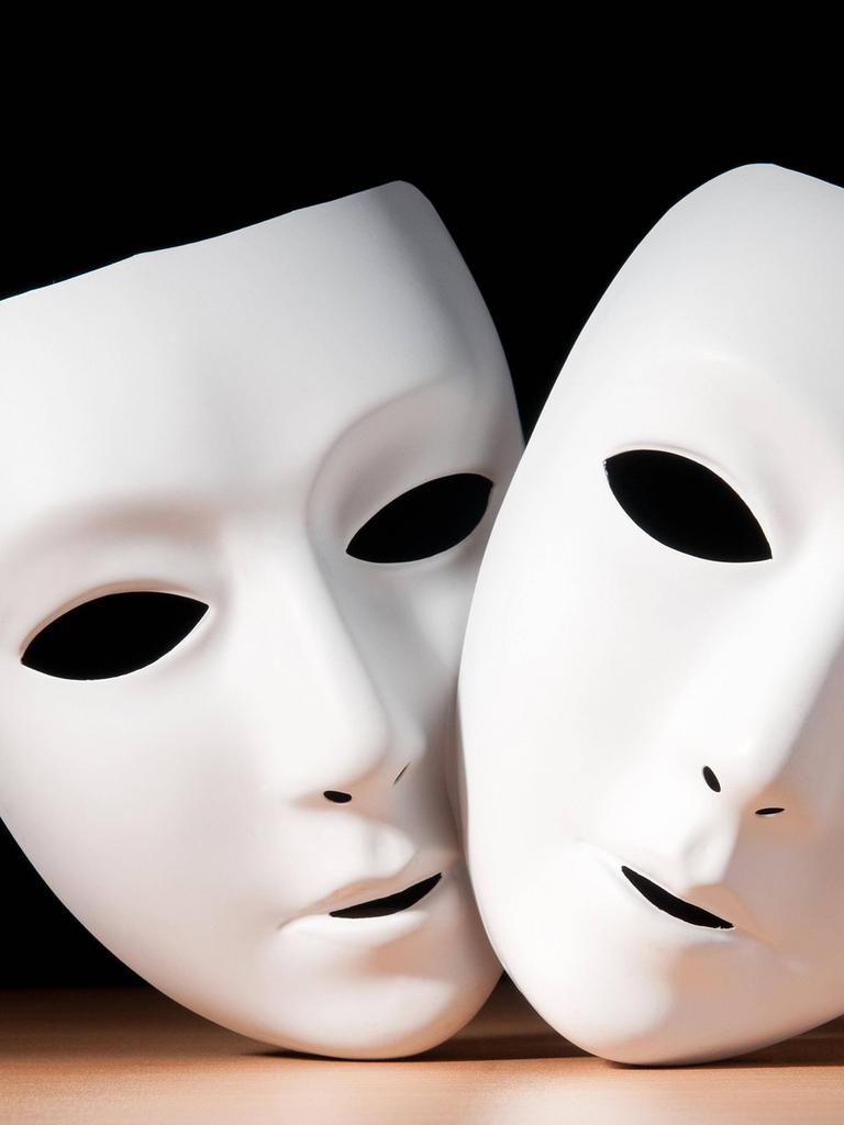 Zwei weiße Gesichtsmasken vor schwarzem Hintergrund