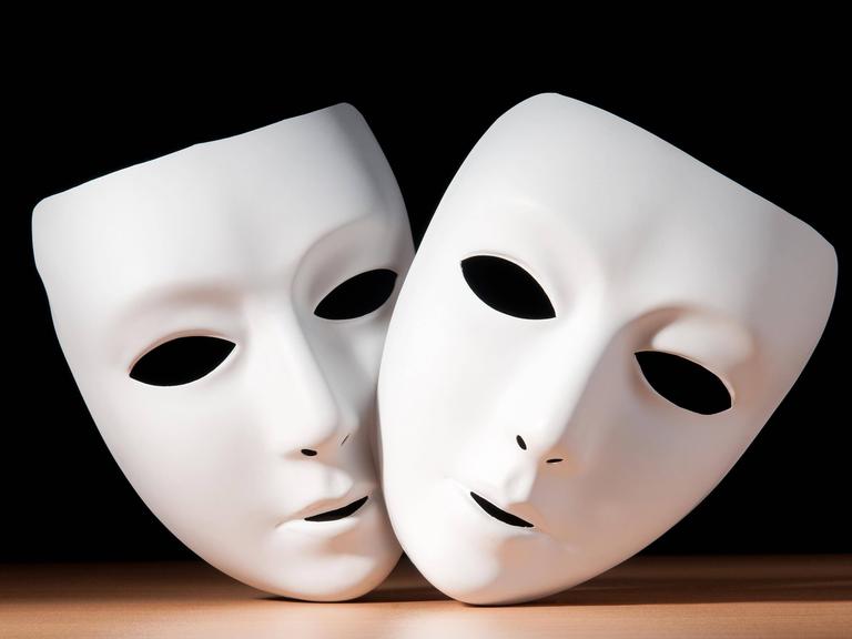 Zwei weiße Gesichtsmasken vor schwarzem Hintergrund