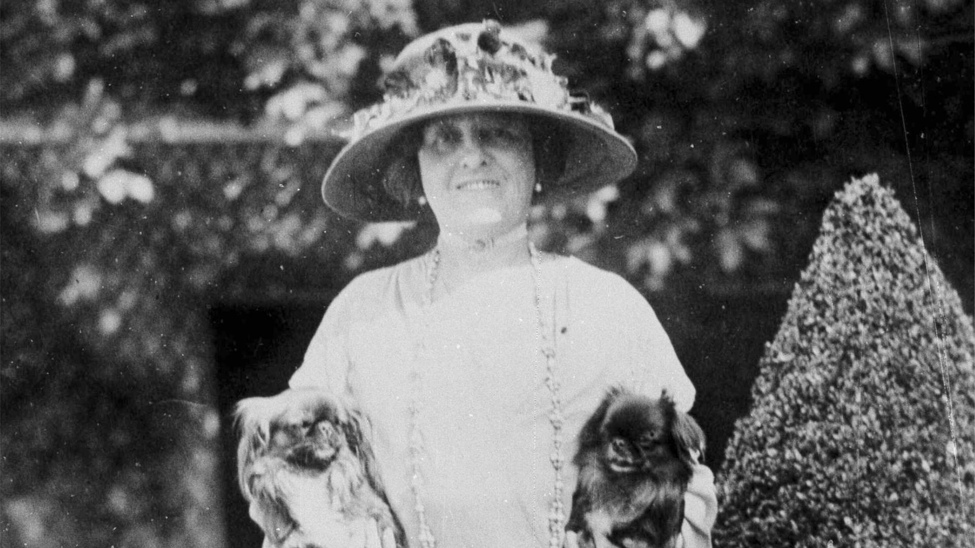 Die Schriftstellerin Edith Wharton auf einem schwarz-weiß Foto. Sie hält in jeder Hand einen kleinen Hund.
